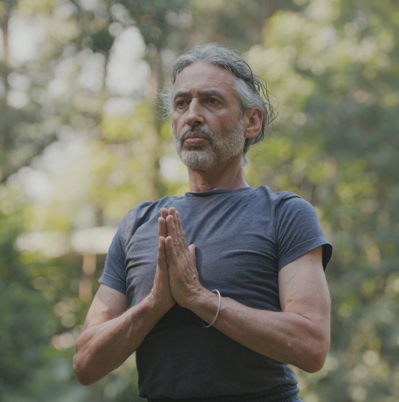 Peter Scott practising yoga in a green garden